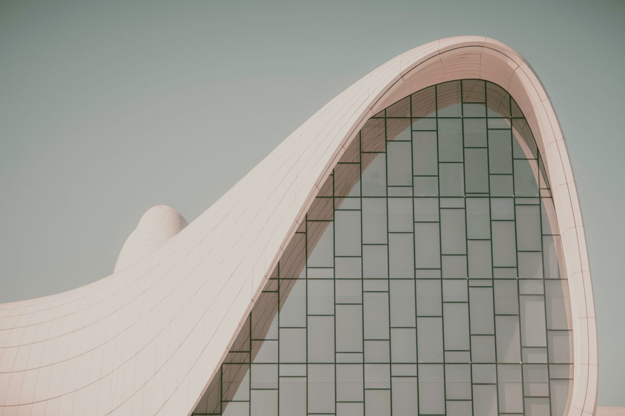 Futuristic curved building with modern glass design, showcasing innovative architectural elements.