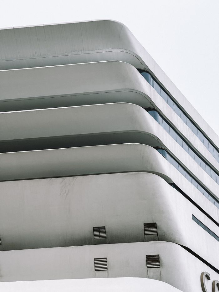 A sleek modern building featuring unique curved lines and minimalistic design elements.
