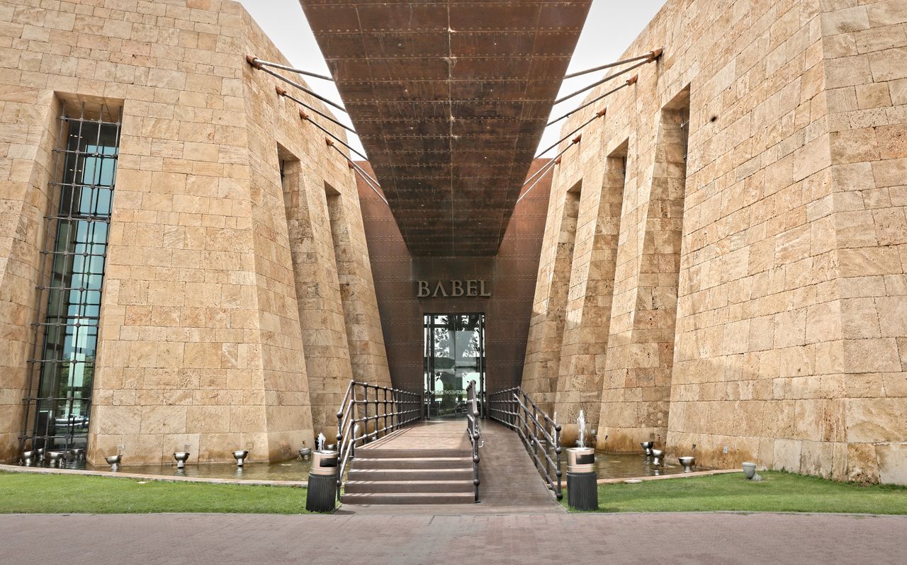 Home Impressive architectural entrance featuring stone walls and metal elements, offering a modern and grandiose feel.